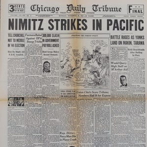 Op de afbeelding: Een vintage exemplaar van de Chicago Daily Tribune krant van 15 november 1943, met de kop "NIMITZ STRIKES IN PACIFIC". De voorpagina bevat artikelen over WOII, politieke cartoons en oorlogsoverzichten. De krant is vergeeld door de ouderdom.