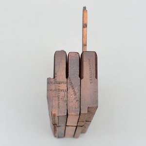 Puede incluir: Cuatro cepillos de mano de madera con cuchillas de metal. Los cepillos están apilados uno encima del otro. El cepillo superior tiene el texto "T. WELLINGTON" impreso en él. El segundo cepillo tiene el texto "MORRIS & SONS" impreso en él. El tercer cepillo tiene el texto "T.E. PERVIS / MANUFACTURING / LONDON" impreso en él. El cepillo inferior tiene el texto "F.W.J. PERVIS / MANUFACTURING / LONDON" impreso en él.