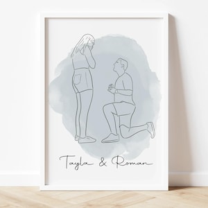May include: A framed line art print depicts a marriage proposal scene. A man kneels before a woman, both figures outlined in black against a light blue watercolor wash. The names "Tayla & Roman" are written in cursive below the figures.