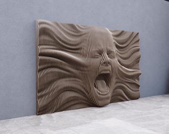 May include: A large, brown, wall-mounted sculpture depicting a screaming face. The artwork is made of layered, vertical wooden strips, creating a textured, three-dimensional effect. The face is in profile, with an open mouth and furrowed brow.