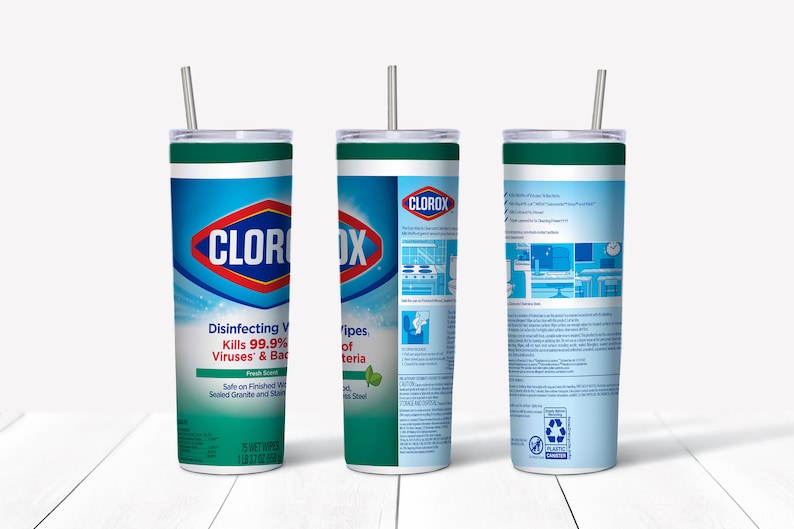 May include: A stainless steel tumbler with a green lid and a straw. The tumbler is wrapped with a Clorox Disinfecting Wipes label. The label features the Clorox logo, product information, and a green leaf design. The tumbler is on a white wooden surface.