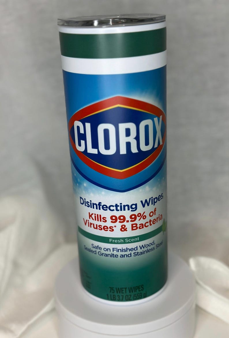 May include: A white and blue can with a green lid. The can has the Clorox logo and the text "Disinfecting Wipes Kills 99.9% of Viruses* & Bacteria Fresh Scent Safe on Finished Wood, Sealed Granite and Stainless Steel 75 WET WIPES 1 LB 37 OZ 559 g".