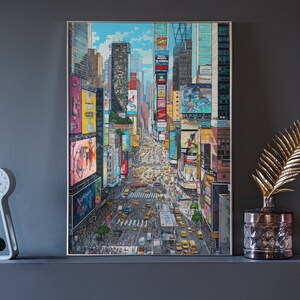Pu&ograve; includere: Un dipinto incorniciato di Times Square a New York, che mostra una vista dall'alto dell'incrocio iconico con i suoi imponenti edifici e i suoi cartelloni luminosi.
