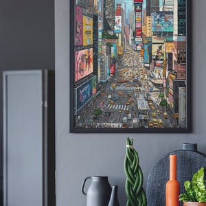 Pu&ograve; includere: Una stampa incorniciata di una citt&agrave; colorata con edifici alti e una scena di strada trafficata. La stampa &egrave; appesa a un muro grigio sopra un tavolo grigio con un vaso, una pianta e una bottiglia.