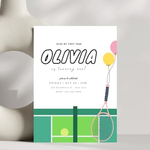 May include: A white invitation card with the text "OLIVIA is turning one!" features a tennis court design, a tennis racket, balloons, and event details. The card includes the text "ACED MY FIRST YEAR".