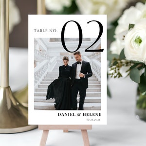 May include: A white table number card with black text and a black and white photo of a couple. The card reads "Table No. 02", "Daniel & Helene", and "10.24.2024".