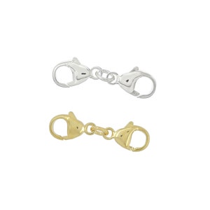 May include: Two lobster claw clasps, one silver and one gold. The clasps are connected by a chain.