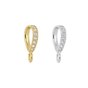 May include: Two pendant bails, one gold and one silver, with a row of clear cubic zirconia stones around the bail.