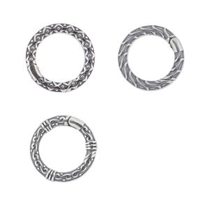 May include: Three silver key rings with different decorative patterns. Each ring is circular and has a smooth, polished finish.