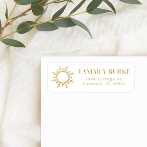 May include: White return address label with a gold sun graphic and the text "TAMARA BURKE", "7944 Cottage St.", "Florence, SC 29501"
