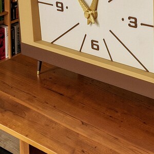 Mid century desk clock detail showing gold style angled legs