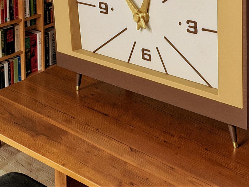 Mid century desk clock detail showing gold style angled legs