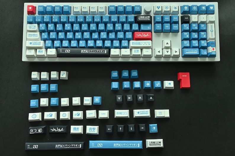 Op de afbeelding: Een wit mechanisch toetsenbord met blauwe en witte toetsen. De toetsen hebben Japanse karakters en symbolen. Er zijn ook verschillende extra toetsen in blauw, wit, zwart en rood.