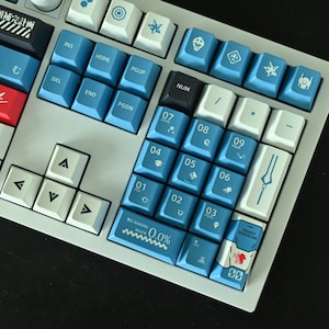 Op de afbeelding: Een wit en blauw mechanisch toetsenbord met een aangepaste toetsenset met een blauw en wit ontwerp met Japanse karakters en symbolen. Het toetsenbord heeft een witte basis en blauwe toetsen met witte letters. De toetsen zijn gemaakt van duurzaam plastic en hebben een gladde afwerking. Het toetsenbord is ontworpen voor gamen en typen.