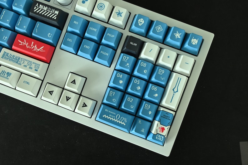 Op de afbeelding: Een wit en blauw mechanisch toetsenbord met een aangepaste toetsenset met een blauw en wit ontwerp met Japanse karakters en symbolen. Het toetsenbord heeft een witte basis en blauwe toetsen met witte letters. De toetsen zijn gemaakt van duurzaam plastic en hebben een gladde afwerking. Het toetsenbord is ontworpen voor gamen en typen.
