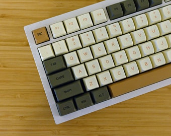 May include: A white mechanical keyboard with brown and gray keys. The keys have white lettering and the keyboard has a brown and beige bottom row.