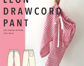 May include: Leon Drawcord Pant PDF sewing pattern for sizes 3M-6Y. The image displays a pair of pink and white gingham pants with a white drawstring waist, alongside a technical line drawing showing the front and back views of the pants.