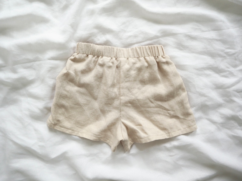May include: A pair of beige linen shorts with an elastic waistband.
