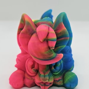 Könnte beinhalten: Eine bunte, mehrfarbige, 3D-gedruckte Figur eines Comic-Tieres mit großen Ohren. Die Figur ist aus einem rosa, blauen und grünen Kunststoffmaterial gefertigt.