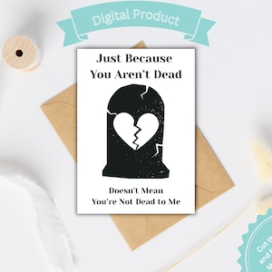 May include: A greeting card with a black tombstone graphic and a broken heart. The text reads "Just Because You Aren't Dead Doesn't Mean You're Not Dead to Me." The card is on a brown envelope.