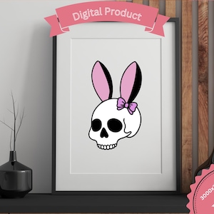 Puede incluir: Impresión digital enmarcada que presenta una calavera blanca con orejas de conejo rosas y un lazo rosa. La imagen está etiquetada como "Digital Product". La obra de arte se exhibe en una estantería negra con un jarrón negro y un fondo de panel de madera decorativo.
