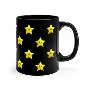 May include: Black ceramic coffee mug with a pattern of yellow stars with black eyes.
