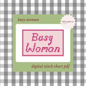 May include: A digital cross-stitch chart PDF with the words "Busy Woman" in pink pixelated letters. The design is on a white background within a pink grid, set against a green rectangle. The background is a gray and white checkered pattern.