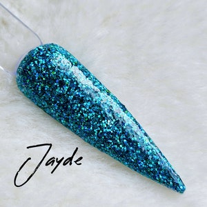 May include: A teal blue nail polish with a glitter finish. The polish is applied to a long, pointed nail.