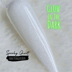 May include: A white, glittery nail swatch with the text "Glow in the Dark" in neon green. The words "Spooky Ghost" and "Fancy Fingers Dips" are also visible in the image.