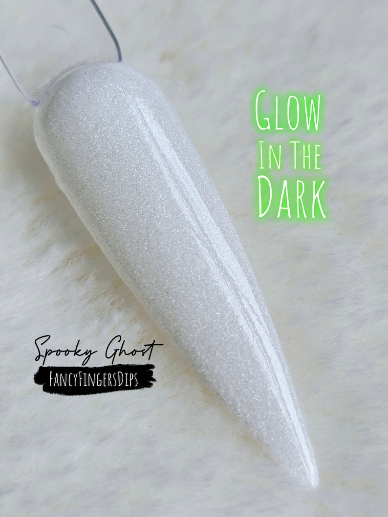 May include: A white, glittery nail swatch with the text "Glow in the Dark" in neon green. The words "Spooky Ghost" and "Fancy Fingers Dips" are also visible in the image.