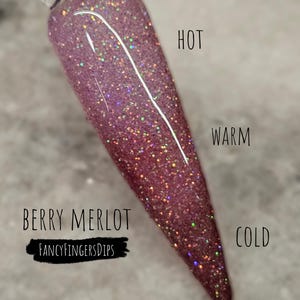 Könnte beinhalten: Ein Nagel-Swatch zeigt einen Berry Merlot-Farbton mit Glitzer. Die Wörter "HOT", "WARM" und "COLD" sind vertikal rechts ausgerichtet. Der Markenname "FANCYFINGERSDIPS" ist ebenfalls sichtbar.