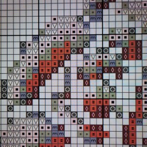May include: A cross-stitch pattern with a variety of colors and shapes, including red, green, blue, and white. The pattern features a geometric design with a repeating motif.