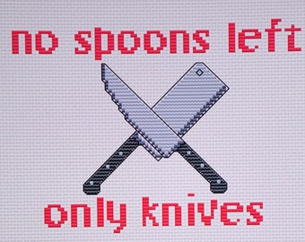 May include: Cross-stitched embroidery with the text "no spoons left only knives" in red thread. Two crossed knives are depicted in the center of the design.