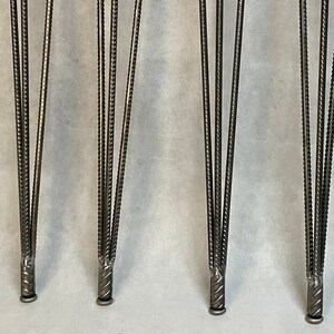 May include: Four silver metal hairpin table legs with a twisted design. The legs are approximately 18 inches tall.