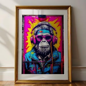 May include: A framed pop art print featuring a monkey wearing headphones and sunglasses. The artwork has a blue, pink, and yellow colour scheme. The frame is gold-coloured.