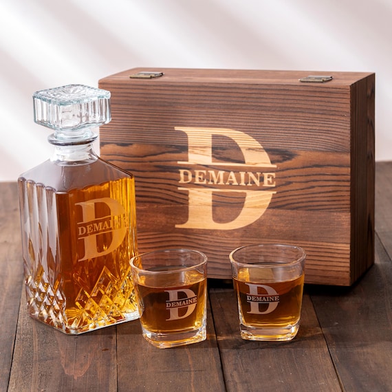 A full engraved whiskey decanter set in a monogrammed wooden box — the kind of groomsmen gift that actually looks expensive on a bar cart.
