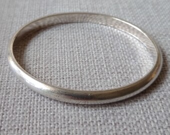 Vintage small plain heavy sterling silver bangle with matte finish in a half pipe oval shape stamped sterling 95