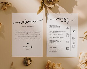 May include: Two white wedding invitation cards with black text. One card says "welcome" and the other says "weekend events". The cards have a minimalist design with a heart and floral accents. The cards are on a beige surface.