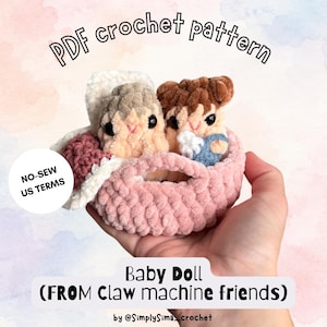 Puede incluir: Un patrón de ganchillo en PDF para una muñeca bebé de máquina de gancho. La imagen muestra dos pequeñas muñecas de ganchillo de felpa con cabello castaño y beige dentro de una cesta rosa. El texto incluye PDF crochet pattern, NO-SEW US TERMS, Baby Doll.