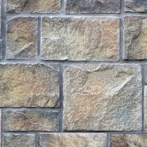 May include: A wall made of brown, gray, and beige stone tiles. The tiles are arranged in a staggered pattern, creating a textured surface.