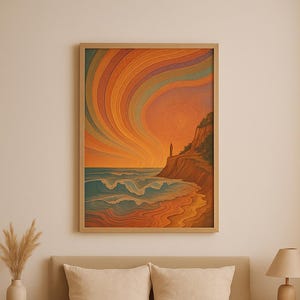 Puede incluir: Una impresión artística enmarcada que representa un paisaje costero con una vibrante puesta de sol. La obra de arte presenta una figura en un acantilado, olas y una playa. La paleta de colores incluye tonos naranja, azul y marrón. La impresión se muestra sobre una cama con ropa de cama beige.