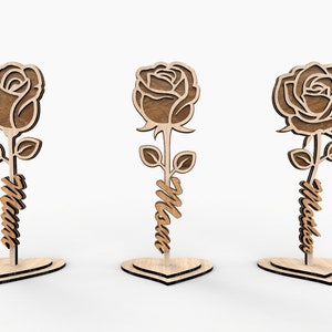 May include: Three wooden rose cutouts with the word "Mom" on the stem. Each rose is standing on a heart-shaped base.
