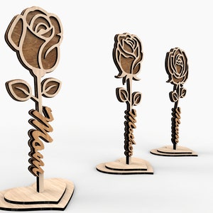May include: Three wooden rose stands with the word "Mom" carved into the stem. Each stand is shaped like a heart.