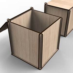 Op de afbeelding: Een houten doos met een scharnierend deksel, open om de lege binnenkant te laten zien. De doos is gemaakt van lichtbruin hout met donkerbruine randen.