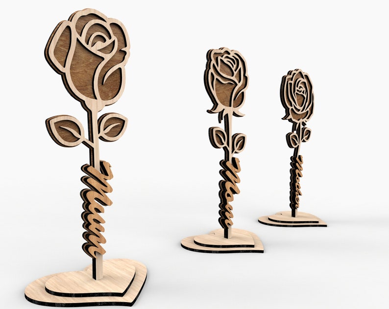 May include: Three wooden rose decorations with a heart-shaped base. The roses are cut out and have a brown wood finish. The stems are wrapped with the word "Mom" in a cursive font.