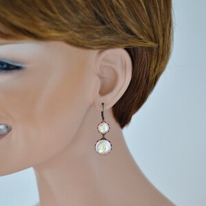 May include: A pair of iridescent pearl drop earrings with a bronze finish.