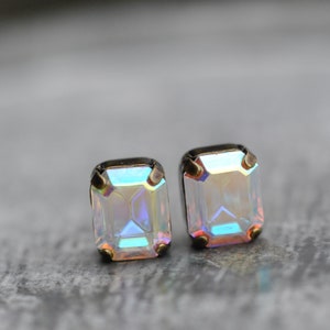Puede incluir: Un par de pendientes de piedra preciosa iridiscente con forma cuadrada y engastes dorados.