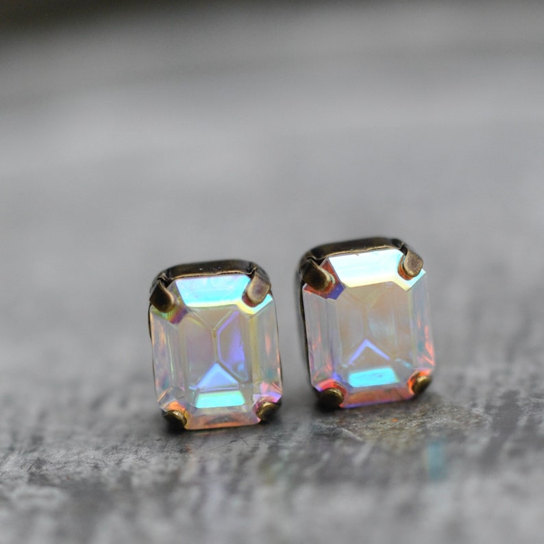 Puede incluir: Un par de pendientes de piedra preciosa iridiscente con forma cuadrada y engastes dorados.