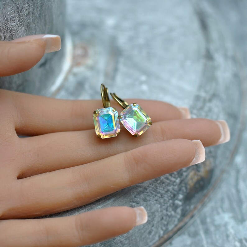May include: A pair of iridescent emerald green gemstone earrings with gold-toned hooks.