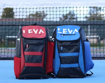 May include: Two LEVA backpacks, one red and black, the other blue and black, are displayed on a blue surface. The backpacks have the word "LEVA" in white on the top. Each backpack has a side pocket and a front zipper pocket.